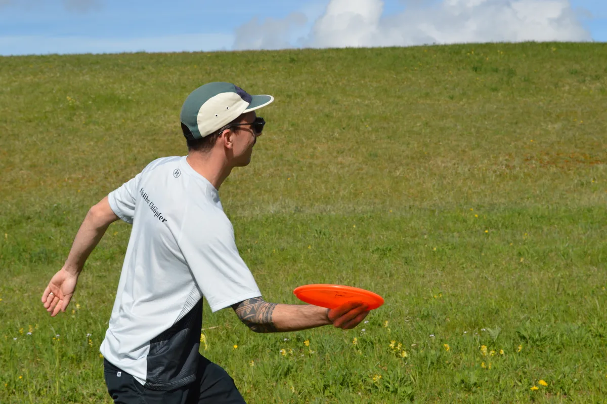 Ein Spieler wirft einen orangefarbenen Disc.